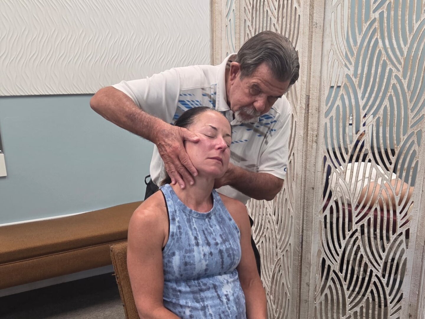Dr. Wuotila performing a seated neck adjustment on a patient at the practice.